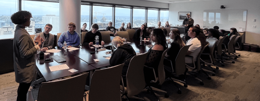 A group of CSF scholars gathered around a conference table listening to a speaker.