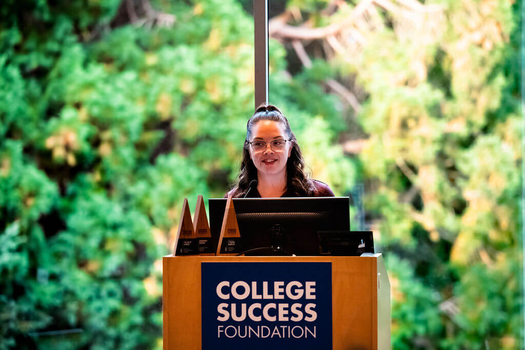 CSF alum Lilia Foma'i stands at a podium speaking