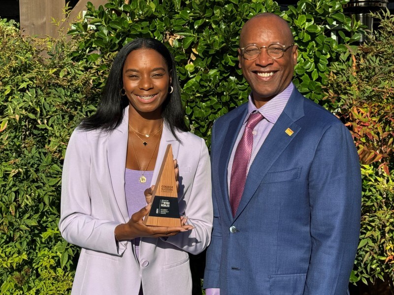James Dorsey stands next to T'wina Nobles, who holds a trophy