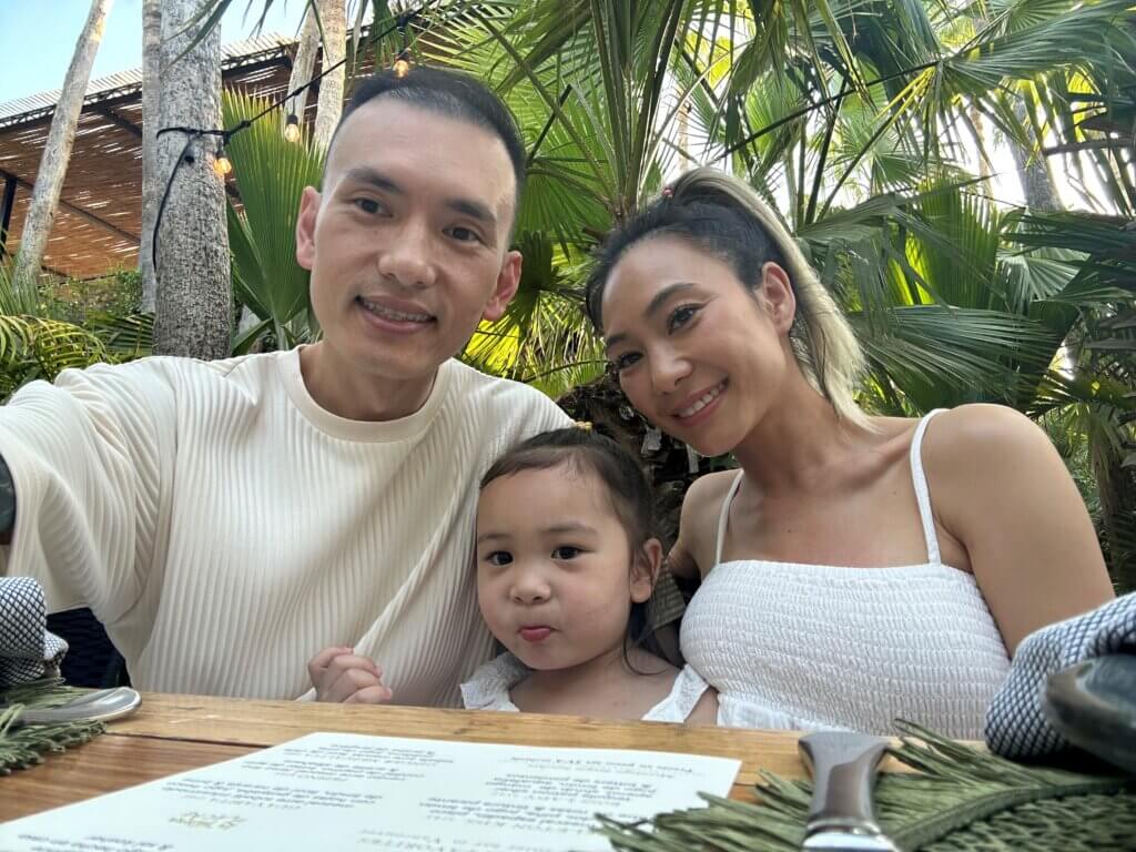 CSF alum Lan Bun sits at a table with her family