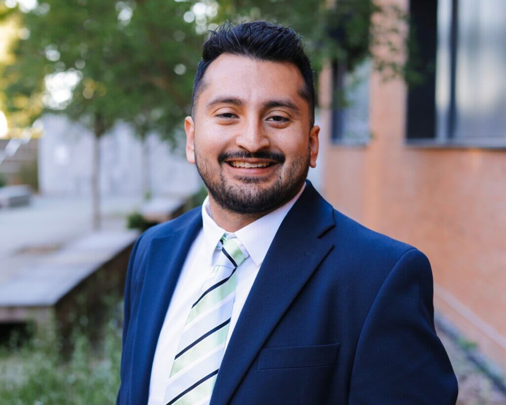 Jose Oronia poses in a suit and tie
